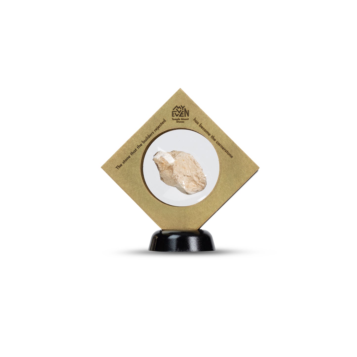 A natural stone is suspended in the middle of a square bronze frame that is set on a round black stand in a diamond position. On the tip of the Diamond is the "MyEvven" logo that says Temple Mount Stones below it. On the top left side of the frame, it reads "The stone that the builders rejected". On the top right side of the frame, it finishes quote "has become the cornerstone".