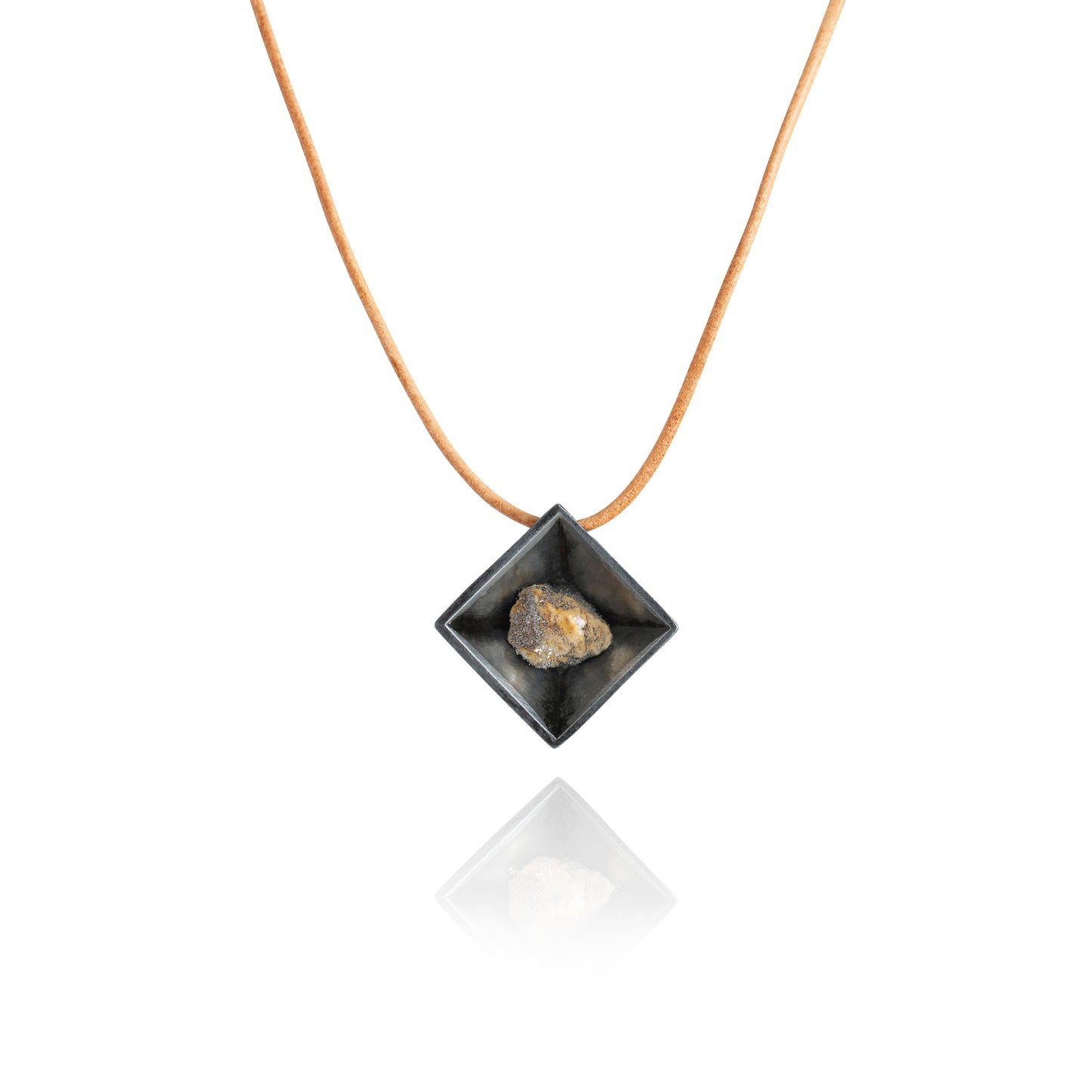 A small natural multicolored stone sitting in the middle of a diamond shaped metal pendant in a dark silver color. The pendant is hanging on a tan leather necklace.