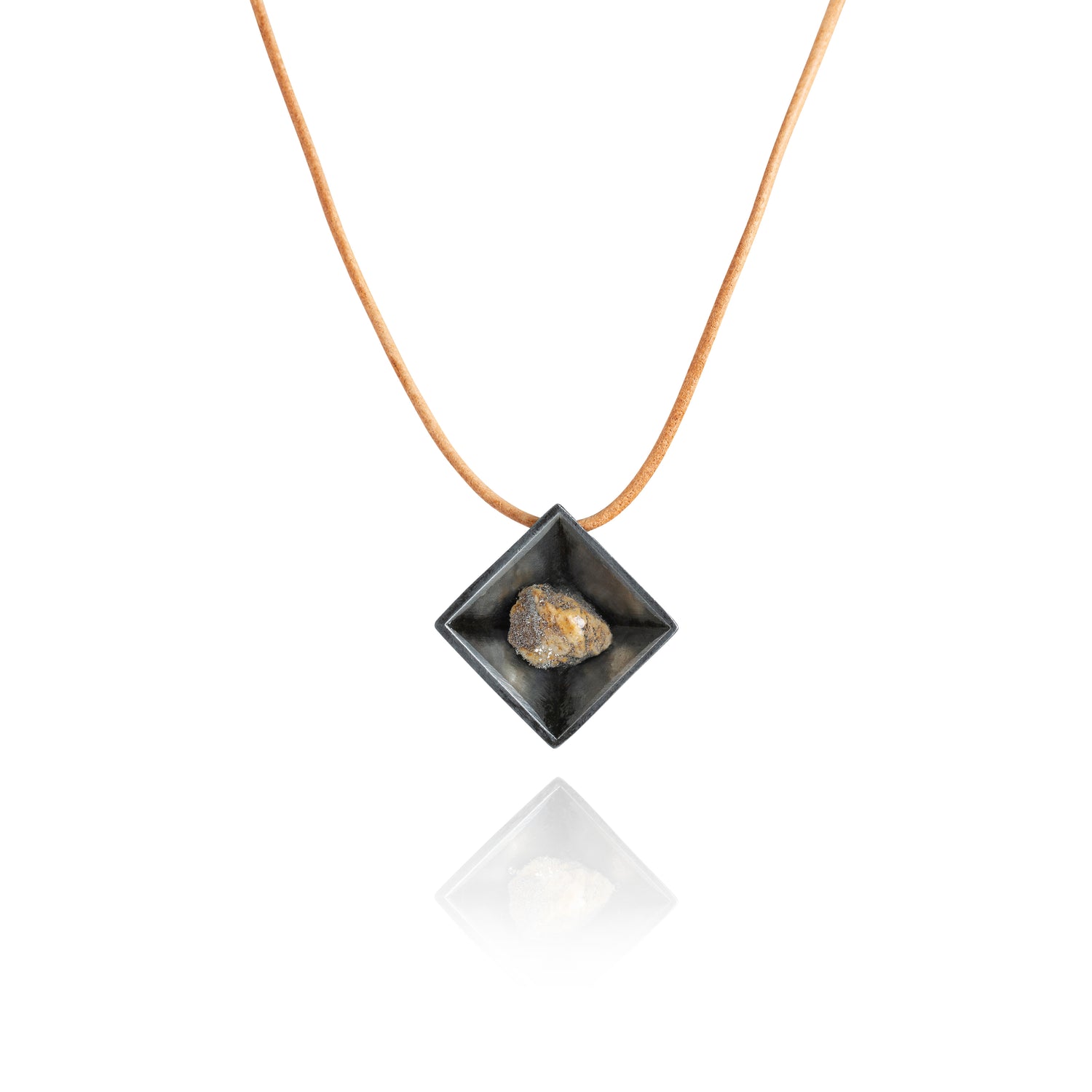 A small natural multicolored stone sitting in the middle of a diamond shaped metal pendant in a dark silver color. The pendant is hanging on a tan leather necklace.