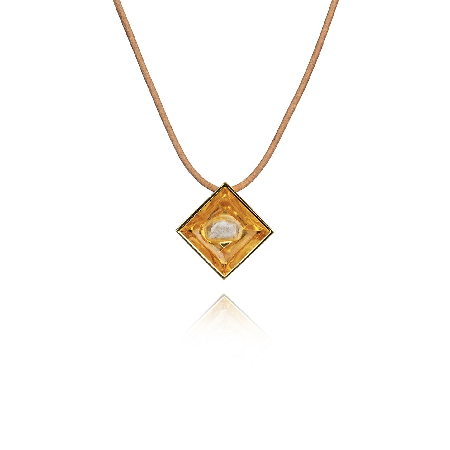 A small natural tan stone sitting in the middle of a diamond shaped metal pendant in a gold color. The pendant is hanging on a tan leather necklace.